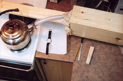 skiis being steamed in wood kettle