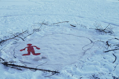 red figure in snow with branches